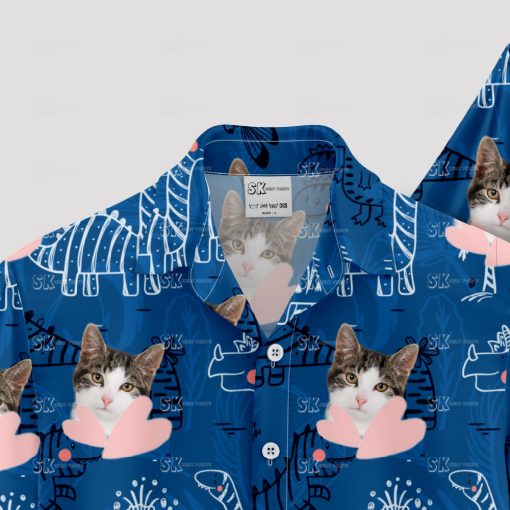 Blue Hawaiian shirt with dinosaur, cat face, and playful pattern