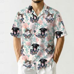 Hawaiian shirt shows black dog and cat faces with butterflies pink flowers design