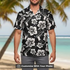 black gun hawaiian shirt with white hibiscus worn by man at beach bar
