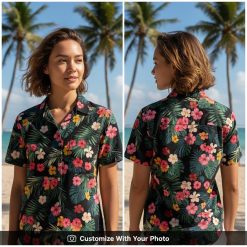 Woman wearing a black Hawaiian shirt with bold tropical flowers and green foliage design
