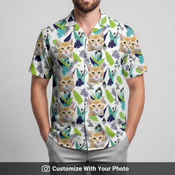 Hawaiian shirt with cat face print worn by man, green palm leaves blue flowers beachside