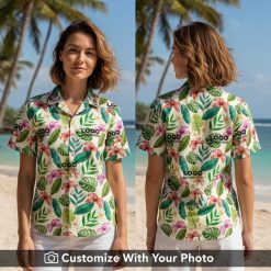 Woman in custom Hawaiian shirt with logo, large tropical flowers and green leaves