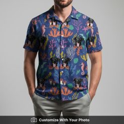 Man in blue Hawaiian shirt with black dog face, coral, and underwater cartoon designs