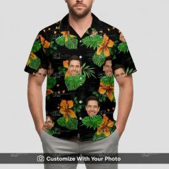 Man wearing custom face black Hawaiian shirt with large green leaves and orange flowers