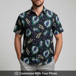 Man in black Hawaiian Aloha shirt with feather leaf and floral print, navy and green colors