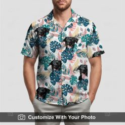 Man in custom Hawaiian shirt, black dog face design, teal pink and beige tropical pattern