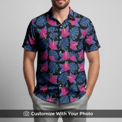 Man wearing vibrant floral Hawaiian shirt with blue monstera leaves and pink hibiscus