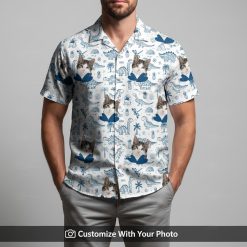 Man wearing tropical blue Hawaiian shirt with cat face, dinosaur, and palm leaf design