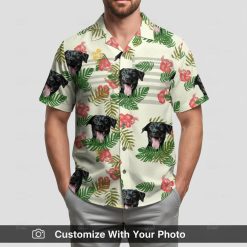 Man in custom Hawaiian shirt, yellow with black dog face, red flowers and green tropical leaves