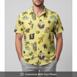 Man in yellow pirate Hawaiian shirt with treasure maps, palm trees, and pirate ship design