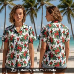 Woman smiling in a vibrant red parrot and hibiscus Hawaiian shirt with green leaves and tropical flowers.