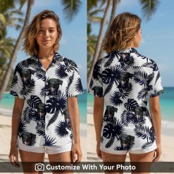 Woman wearing black Hawaiian shirt with playful dog face and tropical blue leaves