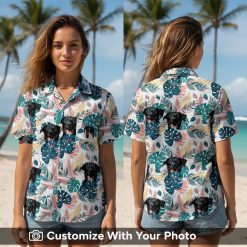 Woman wearing custom Hawaiian shirt with black dog face, teal leaves, and pink accents