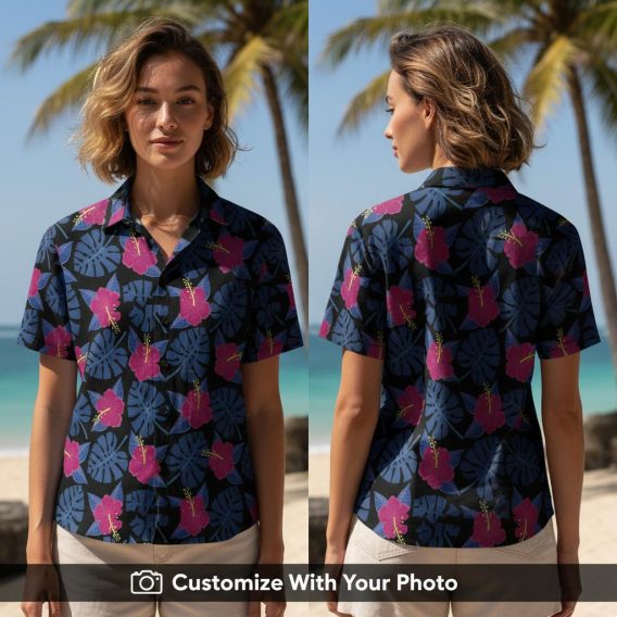 Woman wearing floral print Hawaiian shirt with blue monstera leaves and pink hibiscus flowers