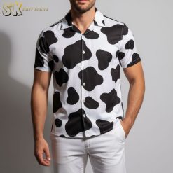 Man in cow spotted Hawaiian shirt posing at beach vacation setting with tropical background