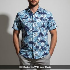 Man in tropical blue Hawaii shirt with swirling palm tree and boat patterns
