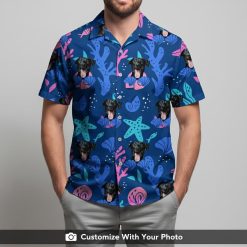 Man in navy blue Hawaiian shirt featuring dog photo, coral, and seashell details