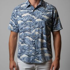 Man in relaxed pose wearing colorful Cooke Street Hawaiian shirt outdoors in natural lighting