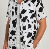 Male model posing in cow print shirt Hawaiian style with black and white spotted pattern