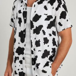 Male model posing in cow print shirt Hawaiian style with black and white spotted pattern