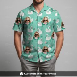 Man in Donald Duck Hawaiian shirt featuring swans, pink flowers, green grass leaves