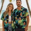 Male model wearing mens parrot Hawaiian shirt in vacation resort setting showing button down style and tropical print