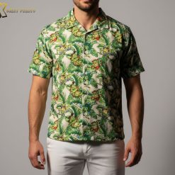 Person modeling colorful turtle themed Aloha shirt against tropical background setting