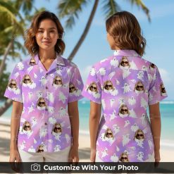 Woman wearing tropical Halloween shirt with pink and purple ghosts and orange star accents