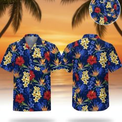 Blue aloha shirt featuring red hibiscus flowers, yellow plumeria, and orange bird of paradise on dark blue background