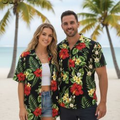 Black and white Hawaiian shirt displaying white plumeria flowers and green leaves on black fabric