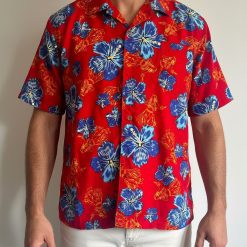 Blue and red Hawaiian shirt displaying tropical floral pattern with blue hibiscus blooms and red flower clusters