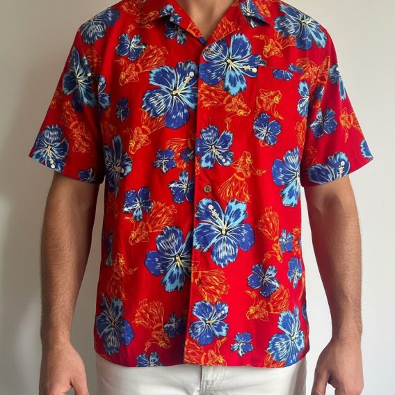 Blue and red Hawaiian shirt displaying tropical floral pattern with blue hibiscus blooms and red flower clusters