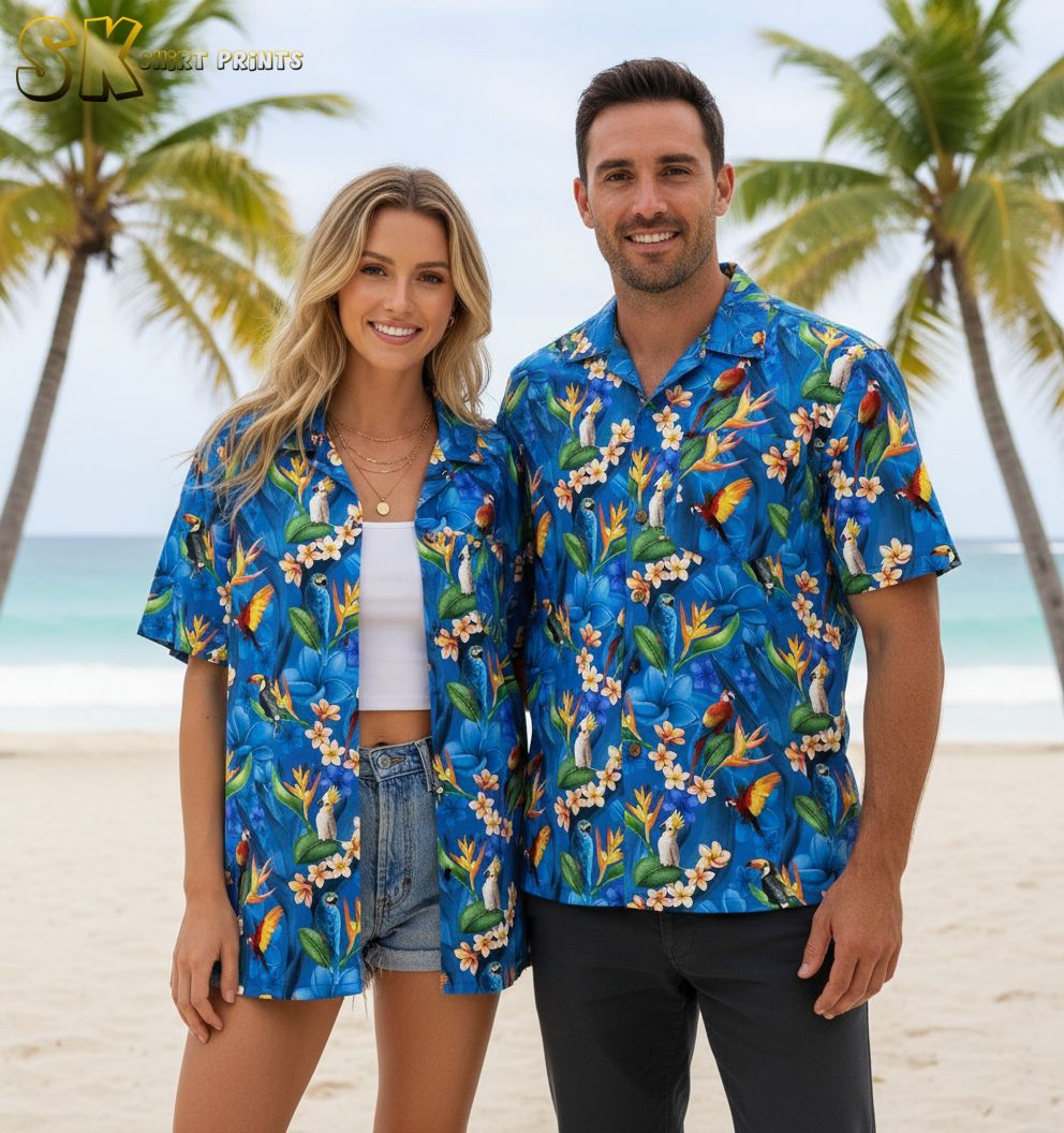 Blue floral hawaiian shirt with white plumeria flowers, orange bird-of-paradise blooms, and tropical bird motifs