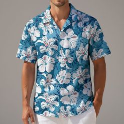 Blue floral Hawaiian shirt displaying white hibiscus blooms with leafy tropical elements