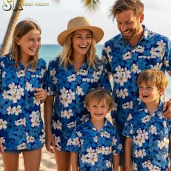 Blue tropical shirt featuring white plumeria flowers with yellow centers in scattered tropical pattern