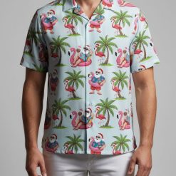 Christmas Hawaiian shirt displaying Santa in shorts and hat on pink flamingo floats with tropical palm tree background