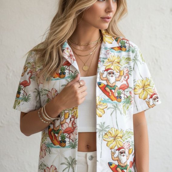 Cotton Christmas Hawaiian shirt with Santa wearing sunglasses surfing, surrounded by pink hibiscus flowers and palm trees