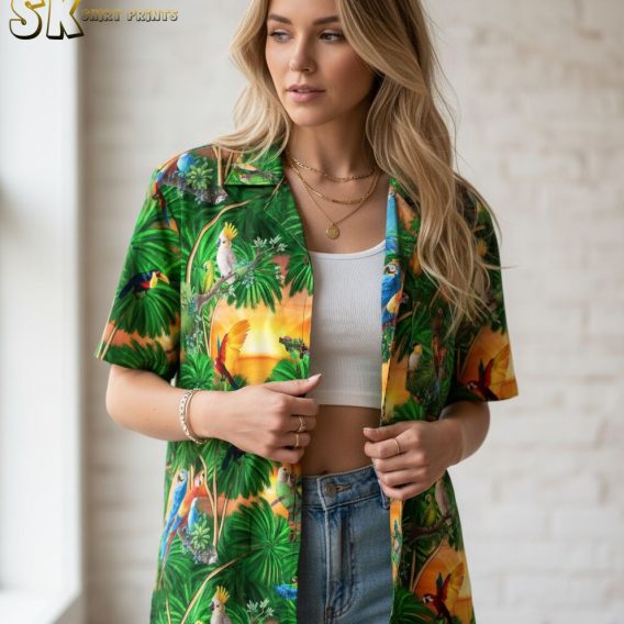 Dark green Hawaiian shirt showing tropical birds and palm leaves in rich green tones with sunset accents