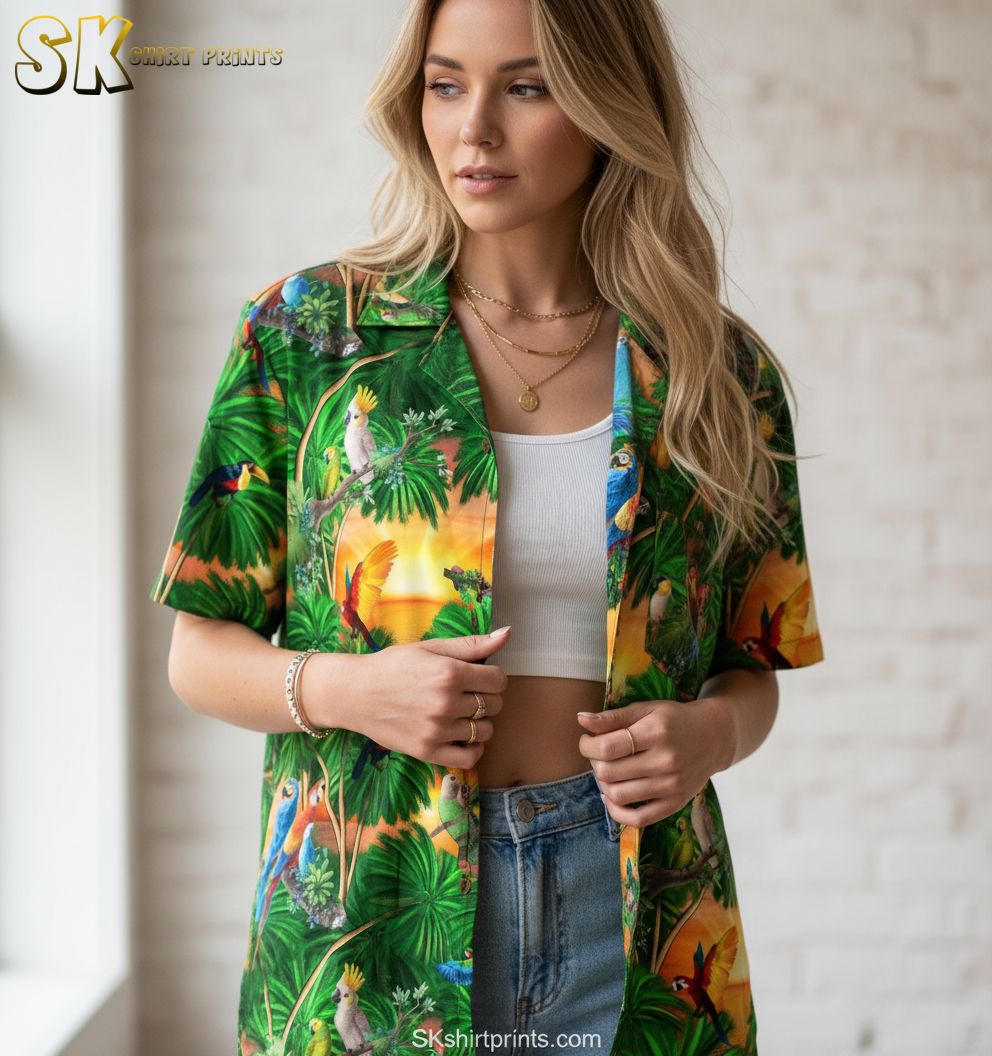 Dark green Hawaiian shirt showing tropical birds and palm leaves in rich green tones with sunset accents