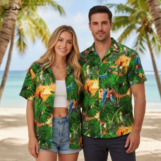 Green aloha shirt displaying colorful toucans and parrots among tropical palm leaves with sunset elements
