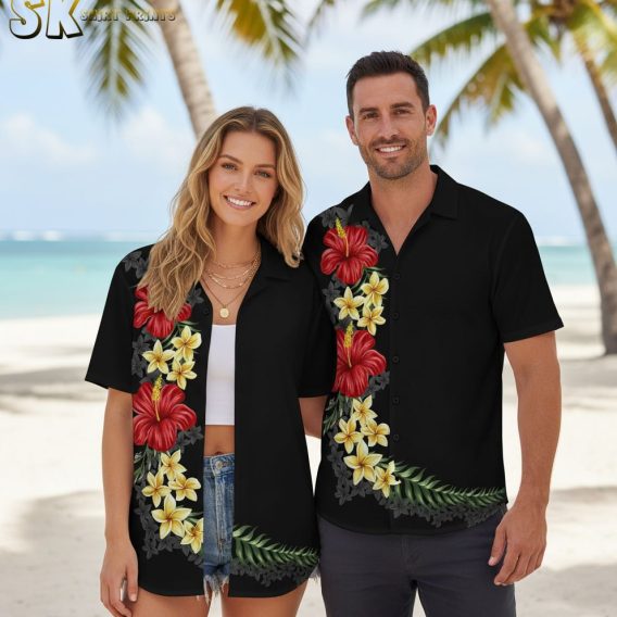 Mens black Hawaiian shirt displaying red hibiscus flowers with yellow plumeria and tropical foliage