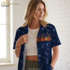 Mens blue hawaiian shirt showing guitar instruments mixed with tropical pineapple and palm imagery