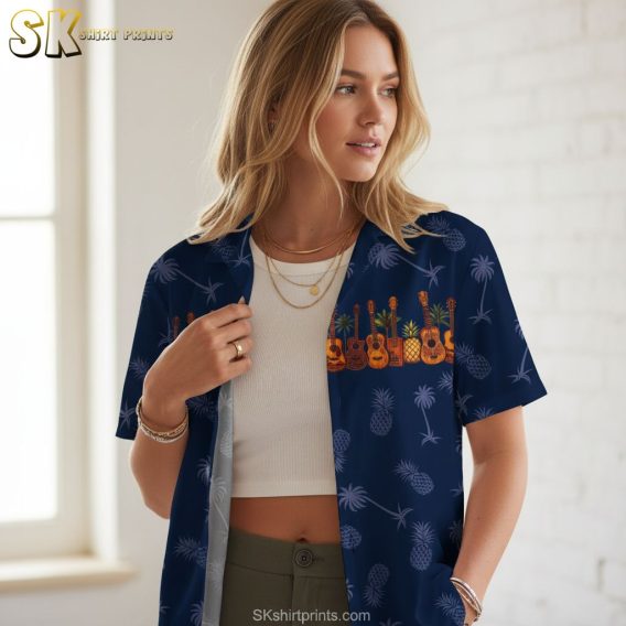 Mens blue hawaiian shirt showing guitar instruments mixed with tropical pineapple and palm imagery