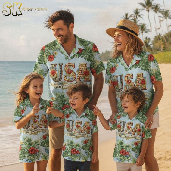 America 250 Hawaiian shirt for sale featuring bold red yellow and blue flowers, large green leaf print, USA graphic with red and gold lettering, and a 250 Years of Freedom banner on a light blue aloha shirt