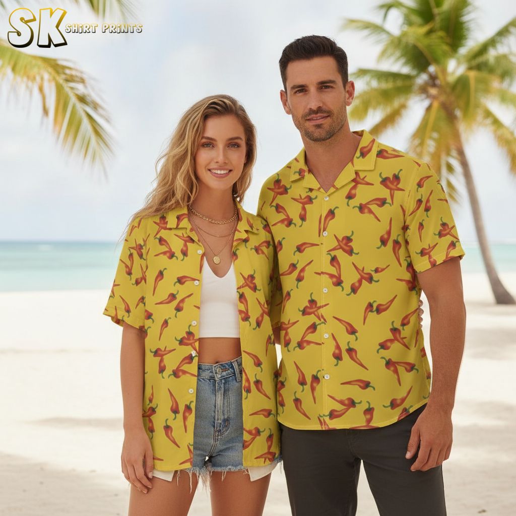 Black and yellow Hawaiian shirt with red chili peppers and green stems creating colorful contrast on yellow base