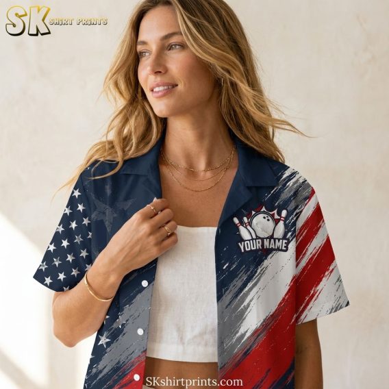 Female model wearing a bowling Hawaiian shirt with red, white, and blue stars and stripes pattern and bowling ball and pins graphic, shown in an airy lifestyle closeup