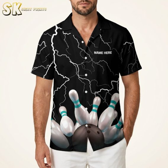 Male model wearing a Hawaiian bowling shirt with white lightning bolt print and bowling pin graphic on a black background, studio setting.
