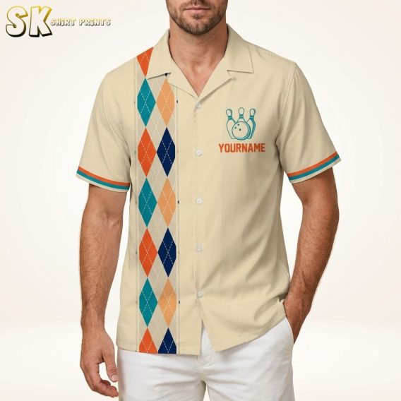 Male model wearing a Hawaiian bowling shirt with an argyle diamond pattern in blue, orange, and beige on a warm white studio background