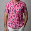 Men's pink tropical shirt displaying colorful summer pattern with surfboards, cocktails, and tropical accessories
