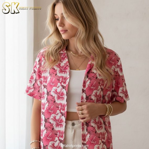 Pink mens Hawaiian shirt showing repetitive hibiscus flower design with white and green accents